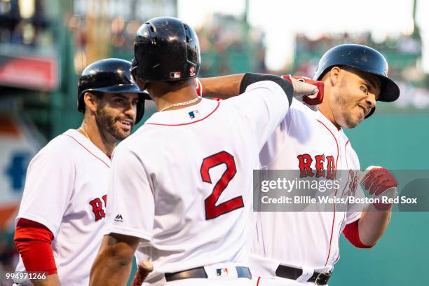 Steve Pearce of the Boston Red Sox reacts with J.D. Martinez and Xander Bogaerts after hitting a two run home run during the first inning of a game...