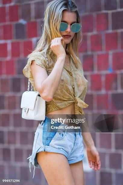 Joy Corrigan is seen wearing a Chasing Unicorns top, One Teaspoon jean shorts with Buffalo London sneakers in the Lower East Side on July 9, 2018 in...