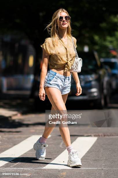 Joy Corrigan is seen wearing a Chasing Unicorns top, One Teaspoon jean shorts with Buffalo London sneakers in the Lower East Side on July 9, 2018 in...