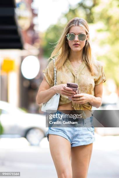 Joy Corrigan is seen wearing a Chasing Unicorns top, One Teaspoon jean shorts with Buffalo London sneakers in the Lower East Side on July 9, 2018 in...