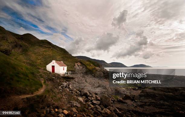 isolated sea side cottage with sweeping sea view - english cottage stock-fotos und bilder