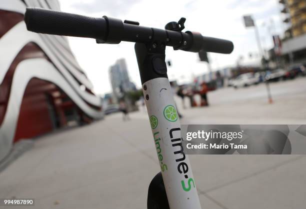 Lime dockless electric scooter is parked on a Wilshire Boulevard sidewalk, available for its next rider, on July 9, 2018 in Los Angeles, California....