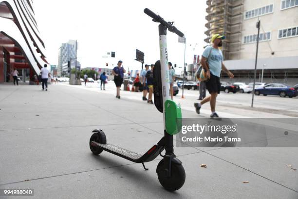 Lime dockless electric scooter is parked on a Wilshire Boulevard sidewalk, available for its next rider, on July 9, 2018 in Los Angeles, California....