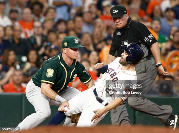 Matt Chapman of the Oakland Athletics tags out Jose Altuve of the Houston Astros as he tried to advance on passed ball in the fourth inning at Minute...