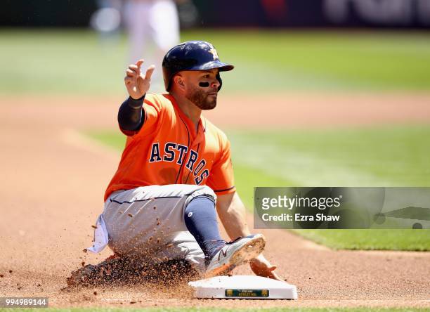 Jose Altuve of the Houston Astros slides in to third base against the Oakland Athletics at Oakland Alameda Coliseum on May 9, 2018 in Oakland,...