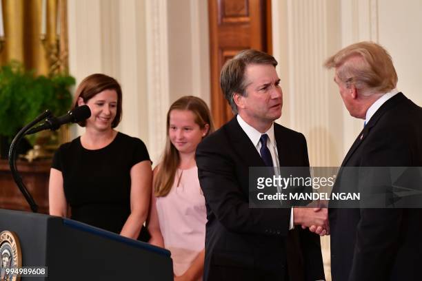 President Donald Trump congratulates his Supreme Court nominee Brett Kavanaugh after he announced his nomination in the East Room of the White House....
