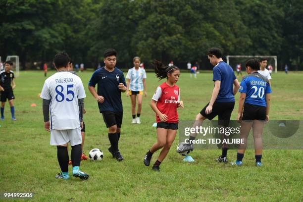 This photo taken on June 27, 2018 shows student football club players training on a school pitch in Manila. - Shirts are selling briskly, crowds pack...