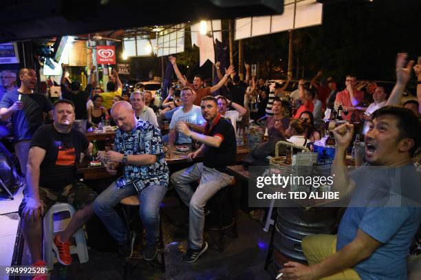 This photo taken on June 30, 2018 shows fans reacting as they watch the 2018 Russia World Cup match between France and Argentina at a bar in Manila....