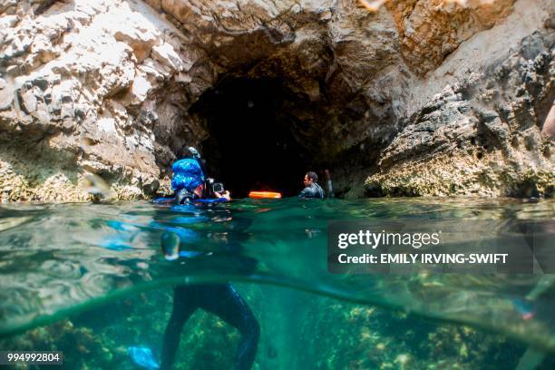 Marine biologist films as members of the Cypriot department of fisheries and marine research enter a cave to collect data from cameras they installed...