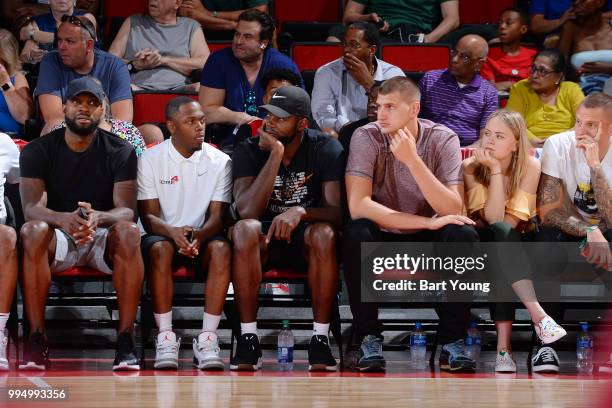 Paul Millsap and Nikola Jokic of the Denver Nuggets sit court side as they play against the Milwaukee Bucks during the 2018 Las Vegas Summer League...