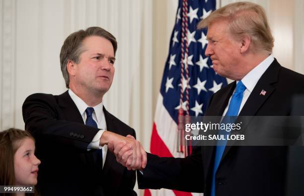 Judge Brett Kavanaugh shakes hands with US President Donald Trump after being nominated to the Supreme Court in the East Room of the White House on...