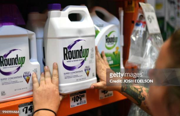 An employee adjusts Roundup products on a shelf at a store in San Rafael, California, on July 2018. A lawyer for a California groundskeeper dying of...