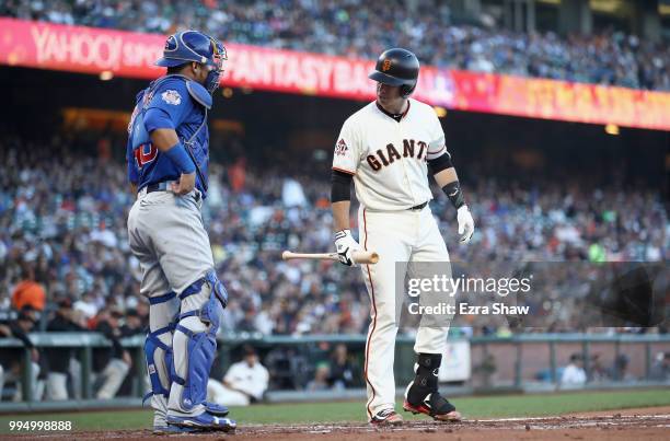 Buster Posey of the San Francisco Giants talks with Willson Contreras of the Chicago Cubs before his at bat in the first inning at AT&T Park on July...