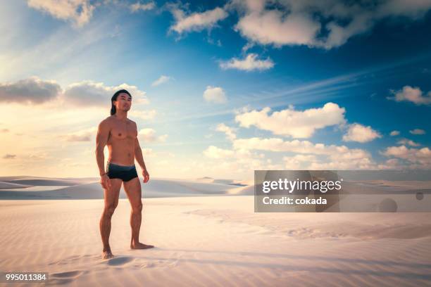 jovem homem musculoso na areia - lencois maranhenses national park - fotografias e filmes do acervo