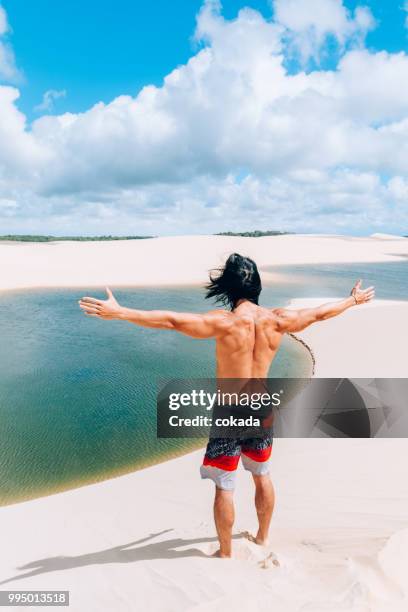 jovem com braços abertos nas areias do lençois maranhenses - lencois maranhenses national park - fotografias e filmes do acervo