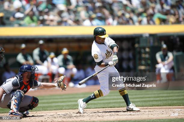 Khris Davis of the Oakland Athletics hits a home run during the game against the Houston Astros at the Oakland Alameda Coliseum on June 14, 2018 in...