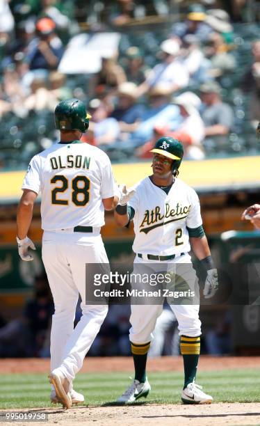Matt Olson of the Oakland Athletics is congratulated by Khris Davis after hitting a home run during the game against the Houston Astros at the...