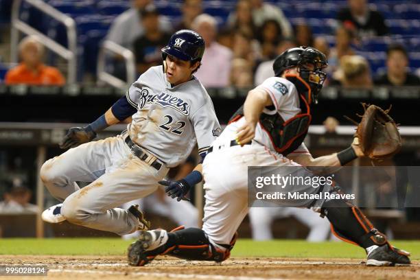 Christian Yelich of the Milwaukee Brewers slides safely past Bryan Holaday of the Miami Marlins to score a run in the eighth inning at Marlins Park...