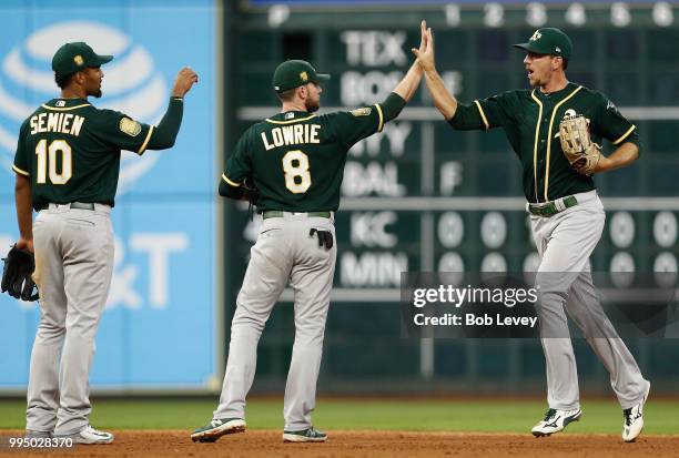 Stephen Piscotty of the Oakland Athletics high fives Jed Lowrie and Marcus Semien after the final out against the Houston Astros at Minute Maid Park...