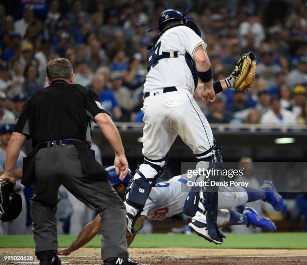 Andrew Toles of the Los Angeles Dodgers scores ahead of the throw to A.J. Ellis of the San Diego Padres during the fifth inning of a baseball game at...