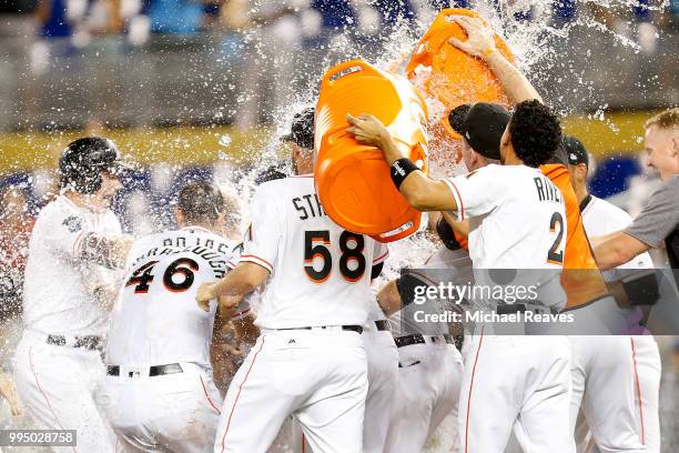 The Miami Marlins celebrate after Bryan Holaday of the Miami Marlins hit a walk-off single in the tenth inning against the Milwaukee Brewers at...