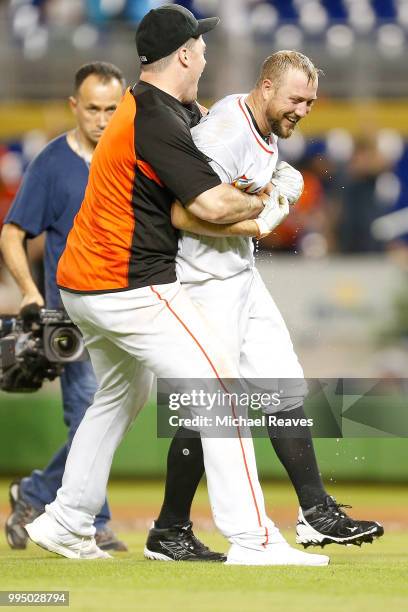 Justin Bour of the Miami Marlins celebrates with Bryan Holaday after he hit a walk-off single in the tenth inning against the Milwaukee Brewers at...