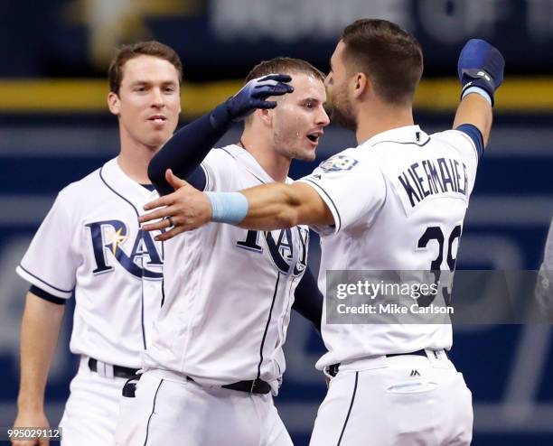 Daniel Robertson of the Tampa Bay Rays, center, hugs Kevin Kiermaier after hitting him in with the game-winning run in the 10th inning of a baseball...