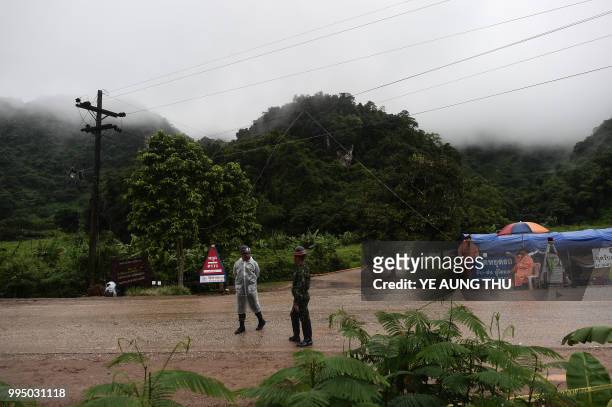 Thai soldiers stand guard outside the Tham Luang cave area as rescue operations continue for those still trapped inside the cave in Khun Nam Nang Non...