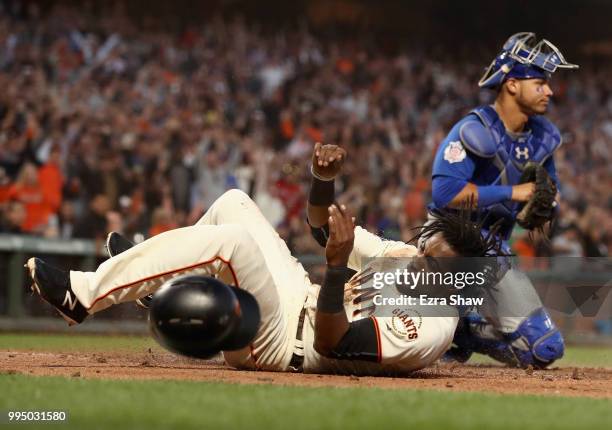 Alen Hanson of the San Francisco Giants beats the tag of Willson Contreras of the Chicago Cubs to score after a failed pick off attempt in the fifth...