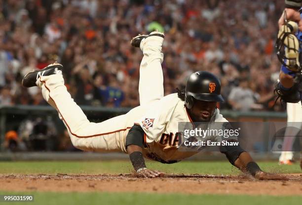 Alen Hanson of the San Francisco Giants beats the tag of Willson Contreras of the Chicago Cubs to score after a failed pick off attempt in the fifth...