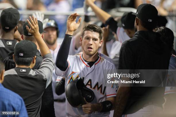 Miami Marlins JT Riddle, center, celebrates scoring the first run for the Marlins at after a sacrifice fly by Marlins catcher Bryan Holiday at...