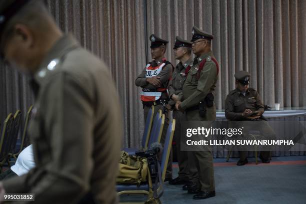 Thai police monitor a press conference by officials at Chiang Rai Prachanukroh Hospital in Chiang Rai on July 10, 2018 as the rescue for a group of...