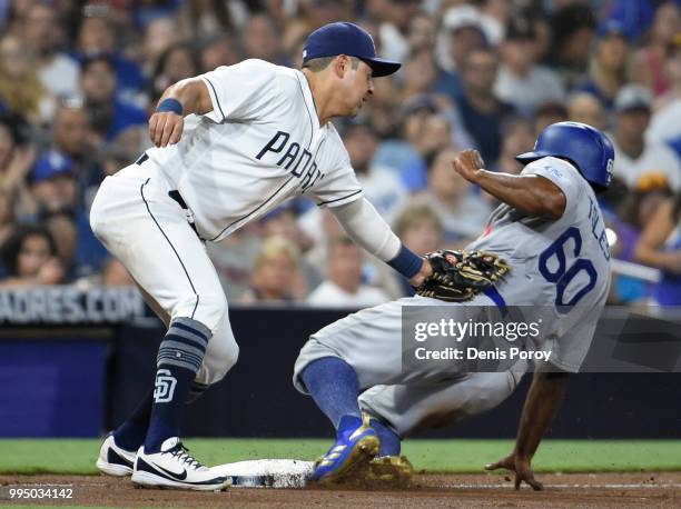 Andrew Toles of the Los Angeles Dodgers slides into third base ahead of the tag of Christian Villanueva of the San Diego Padres during the eighth...