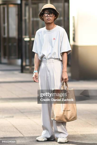 Guest is seen wearing a tan top, tan khakis and a Comme Des Garcons Shirt bag outside New York Men's Day during the 2018 New York City Men's Fashion...