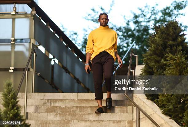 Guest is seen wearing a mustard top and black pants during the 2018 New York City Men's Fashion Week at Creative Drive on July 9, 2018 in New York...