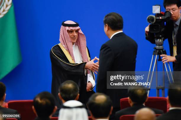 Saudi Arabia's Foreign Minister Adel al-Jubeir shakes hands with China's President Xi Jinping after giving a speech during the 8th Ministerial...