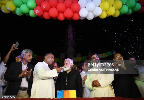 Pakistani Roman Catholic priest offers sweets to the newly-appointed Pakistani Cardinal Joseph Coutts during a welcoming ceremony at Saint Patrick...