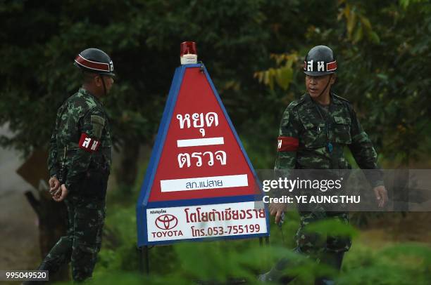 Thai soldiers stand guard outside the Tham Luang cave area as the operations continue for those still trapped inside the cave in Khun Nam Nang Non...