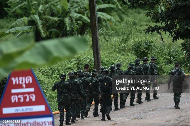 Thai soldiers walk into to the Tham Luang cave area as the operations continue for those still trapped inside the cave in Khun Nam Nang Non Forest...