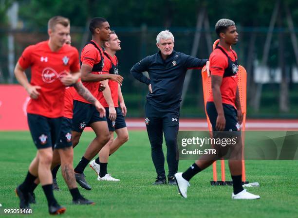 English Premier League side Southampton's Welsh manager Mark Hughes looks on as players take part in a training session before their friendly...