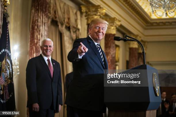 President Donald Trump, points while speaking as U.S. Vice President Mike Pence, left, listens during a swearing in ceremony for Mike Pompeo, U.S....