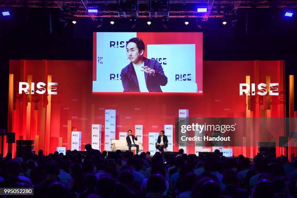 In this handout image provided by RISE, Takeshi Idezawa CEO of LINE Corporation and The Information reporter Juro Osawa speak on centre stage during...