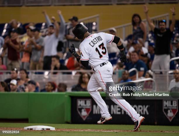 Fan cheer as Starlin Castro of the Miami Marlins hits a home run during the game against the Milwaukee Brewers at Marlins Park on July 9, 2018 in...