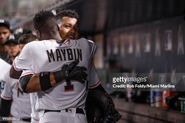 Starlin Castro of the Miami Marlins celebrates in the dugout with Cameron Maybin after hitting a home run during the game against the Milwaukee...