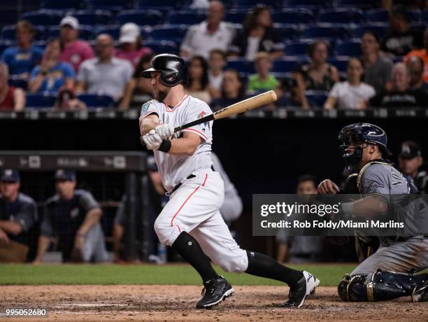 Bryan Holaday of the Miami Marlins hits a walk-off single to end the game against the Milwaukee Brewers at Marlins Park on July 9, 2018 in Miami,...
