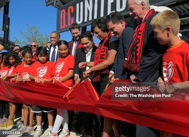 Mayor Muriel Bowser center is flanked be DC United owners Erick Thohir, left and Jason Levien, right, as they cut the ribbon at the dedication of the...