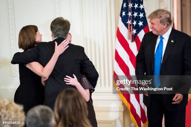 President Donald J. Trump watches as Judge Brett M. Kavanaugh of the District of Columbia Circuit, hugs his family during an announcement ceremony...