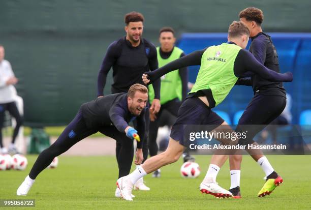 Harry Kane of England attemtps to tag Gary Cahill of England with a toy chicken during the England training session on July 10, 2018 in Saint...