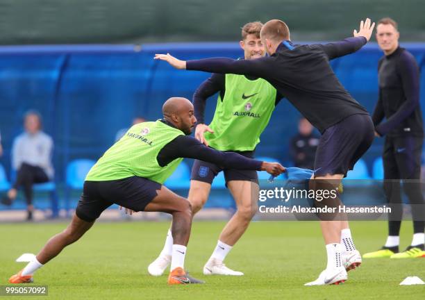 Fabian Delph of England attempts to tag Eric Dier of England with a toy chicken during the England training session on July 10, 2018 in Saint...