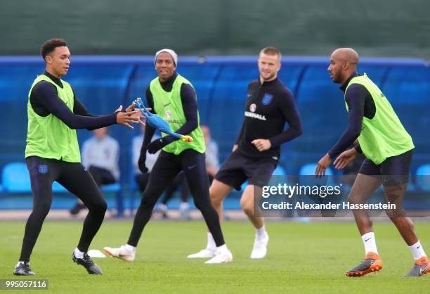 Trent Alexander-Arnold of England catches a toy chicken from Fabian Delph of England during the England training session on July 10, 2018 in Saint...